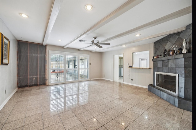 unfurnished living room with baseboards, granite finish floor, and beamed ceiling