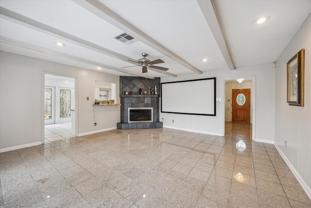 unfurnished living room featuring a tile fireplace, granite finish floor, and beamed ceiling