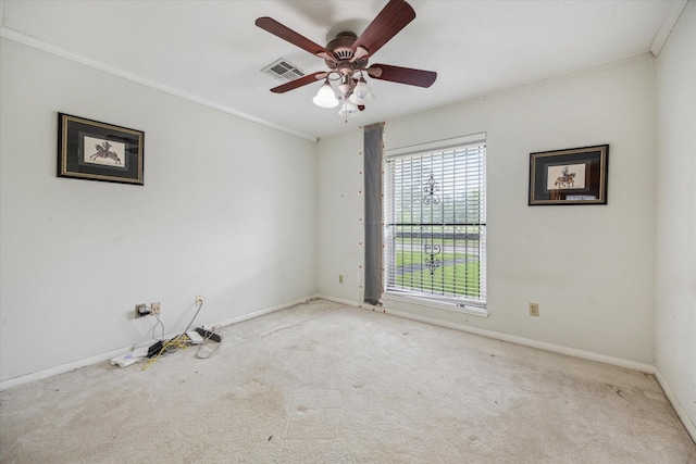 unfurnished room featuring visible vents, a ceiling fan, ornamental molding, baseboards, and carpet flooring