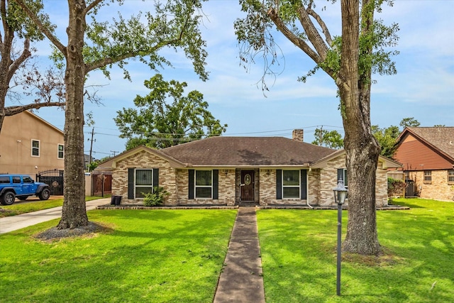 ranch-style home featuring fence, a chimney, a shingled roof, and a front yard