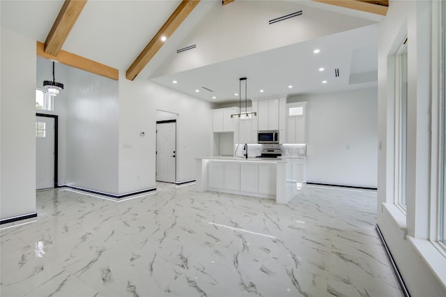 712 Sealy St, Clute, TX 77531 - kitchen with appliances with stainless steel finishes, beam ceiling, a sink, high vaulted ceiling, and white cabinets