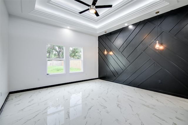 712 Sealy St, Clute, TX 77531 - spare room with baseboards, ceiling fan, a tray ceiling, and marble finish floor