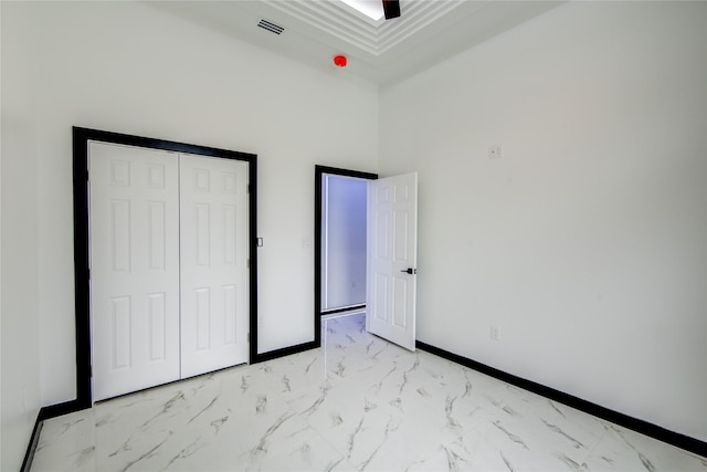 712 Sealy St, Clute, TX 77531 - unfurnished bedroom with visible vents, baseboards, a closet, marble finish floor, and a high ceiling