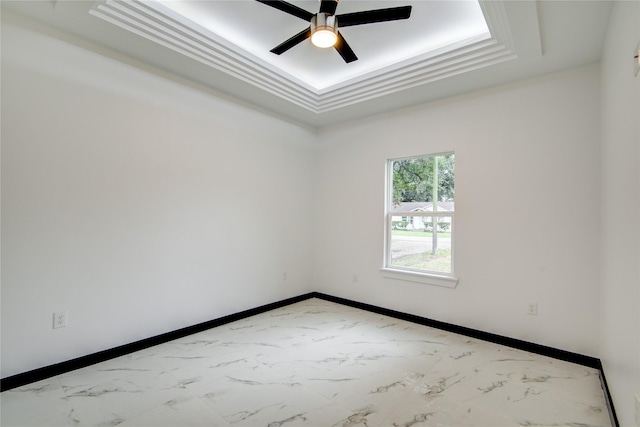 712 Sealy St, Clute, TX 77531 - empty room featuring baseboards, ceiling fan, a tray ceiling, and marble finish floor
