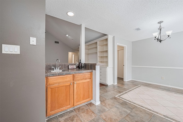 2502 Knollbrook Ln, Spring, TX 77373 - kitchen with a textured ceiling, visible vents, hanging light fixtures, a sink, and a notable chandelier