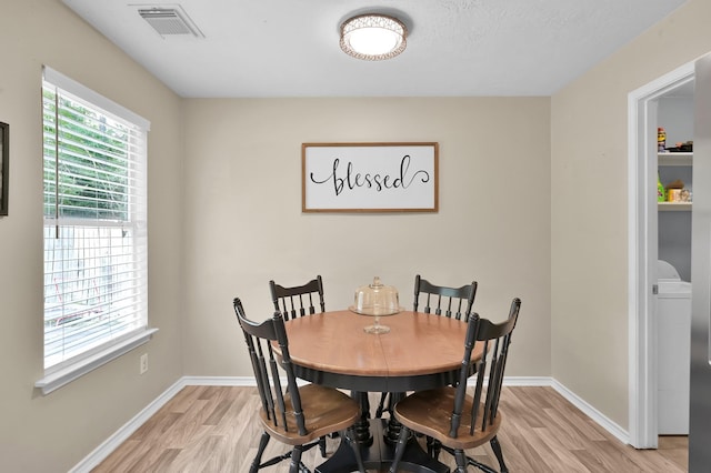 dining room featuring light wood-type flooring, baseboards, and visible vents