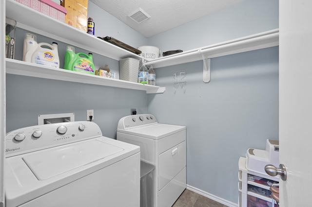 clothes washing area featuring laundry area, a textured ceiling, visible vents, baseboards, and washer and clothes dryer