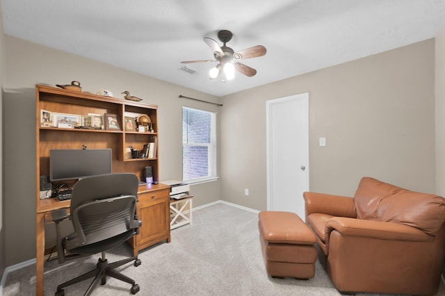 office space featuring baseboards, ceiling fan, visible vents, and light colored carpet