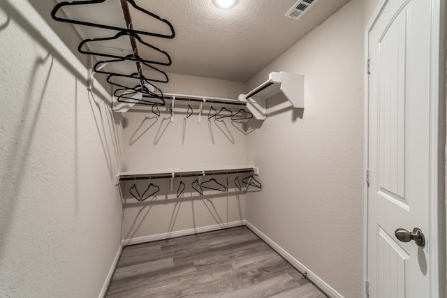 walk in closet featuring wood finished floors and visible vents