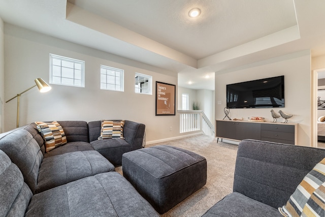 living area with a raised ceiling, baseboards, light carpet, and recessed lighting