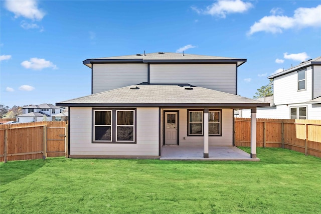 rear view of property with a fenced backyard, a patio area, a yard, and a shingled roof