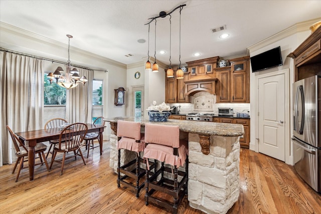 kitchen with visible vents, freestanding refrigerator, ornamental molding, light wood-type flooring, and range