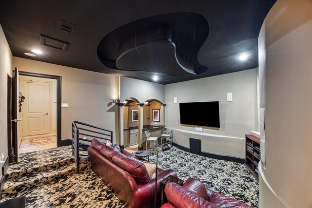 carpeted living room featuring visible vents, arched walkways, baseboards, ornate columns, and recessed lighting