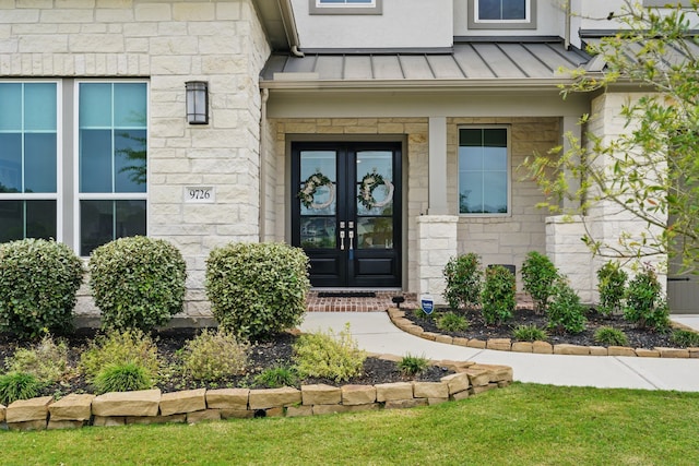 9726 Dani Lake Dr, Tomball, TX 77375 - entrance to property featuring french doors, a standing seam roof, stone siding, and metal roof