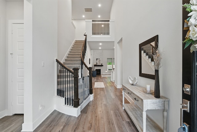 9726 Dani Lake Dr, Tomball, TX 77375 - entryway featuring stairway, wood finished floors, a high ceiling, and baseboards