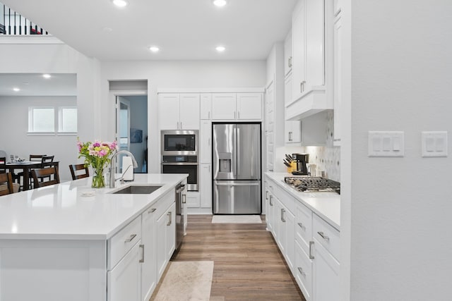 9726 Dani Lake Dr, Tomball, TX 77375 - kitchen with stainless steel appliances, a sink, light countertops, recessed lighting, and light wood-style flooring