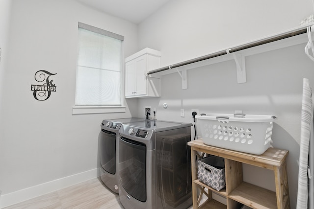 9726 Dani Lake Dr, Tomball, TX 77375 - washroom with cabinet space, washing machine and dryer, baseboards, and light wood-style floors