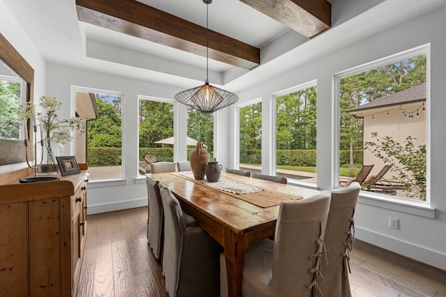 dining room featuring baseboards, light wood-type flooring, and a wealth of natural light
