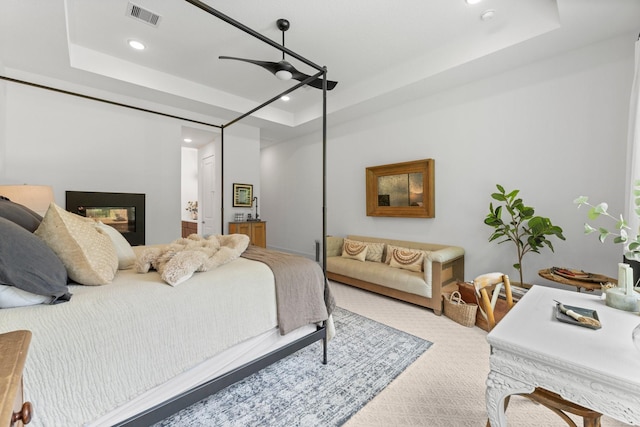 carpeted bedroom with visible vents, ceiling fan, recessed lighting, a raised ceiling, and a multi sided fireplace