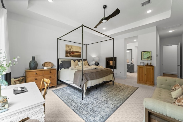 bedroom with visible vents, recessed lighting, a raised ceiling, and light colored carpet