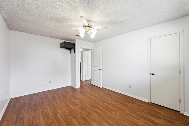 unfurnished bedroom with baseboards, a ceiling fan, a textured ceiling, and wood finished floors