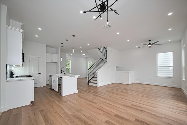 kitchen with visible vents, a sink, light countertops, open floor plan, and stainless steel appliances