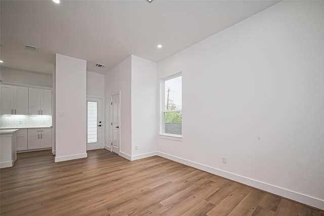 unfurnished living room with recessed lighting, baseboards, visible vents, and light wood-style flooring