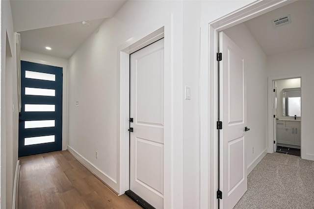 corridor featuring recessed lighting, baseboards, visible vents, and light wood-style flooring