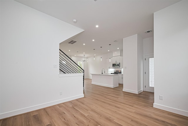 unfurnished living room featuring recessed lighting, baseboards, visible vents, and light wood finished floors