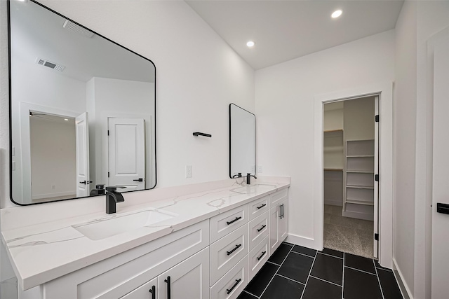 full bath featuring visible vents, a sink, double vanity, and recessed lighting