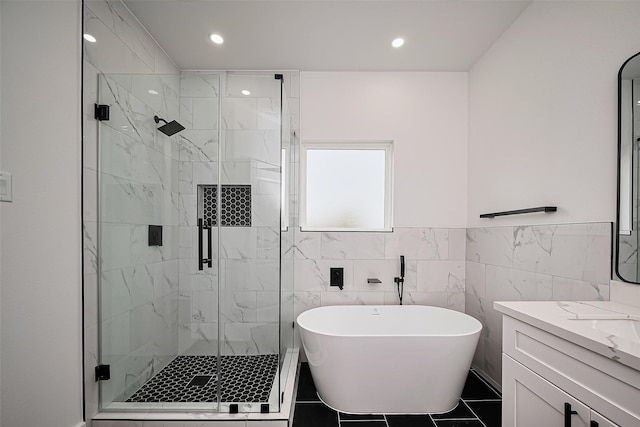 bathroom featuring vanity, a soaking tub, a shower stall, and recessed lighting