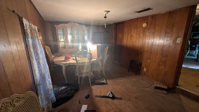 dining room with wood walls and visible vents