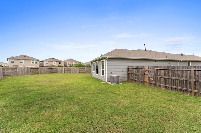 view of yard with central AC unit and a fenced backyard