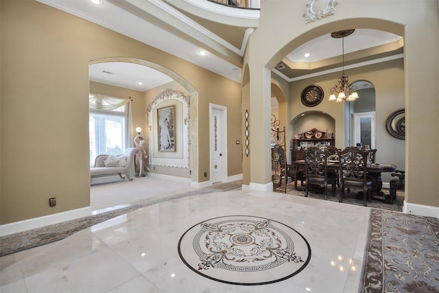 foyer entrance featuring crown molding, baseboards, recessed lighting, a chandelier, and arched walkways