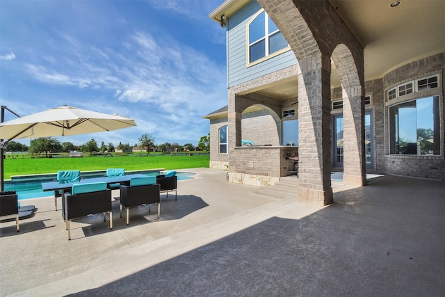 view of patio / terrace with outdoor dining area and an outdoor pool