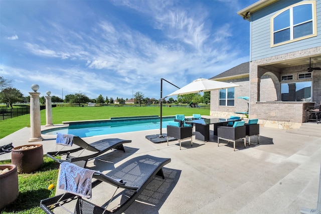 view of swimming pool with a fenced in pool, a yard, and a patio area