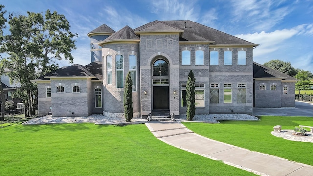 french provincial home featuring a front lawn and brick siding