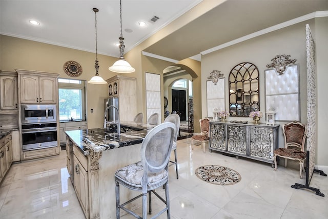 kitchen featuring crown molding, visible vents, a kitchen bar, arched walkways, and appliances with stainless steel finishes