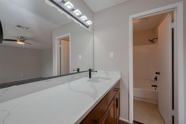 full bathroom featuring a textured ceiling, visible vents, ceiling fan, and vanity