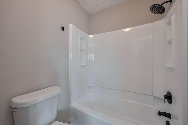 full bathroom featuring a textured ceiling, bathing tub / shower combination, and toilet