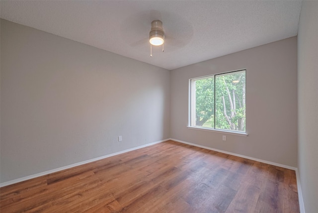 3224 Windchase Blvd Unit 495, Houston, TX 77082 - empty room with wood finished floors, baseboards, a ceiling fan, and a textured ceiling