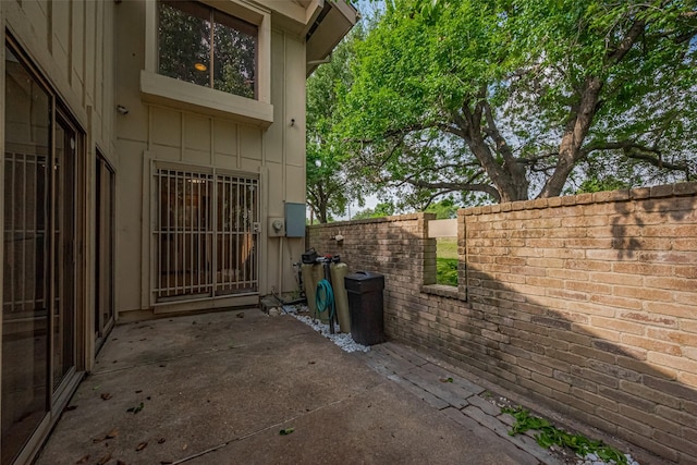 view of property exterior featuring board and batten siding, a patio area, and fence