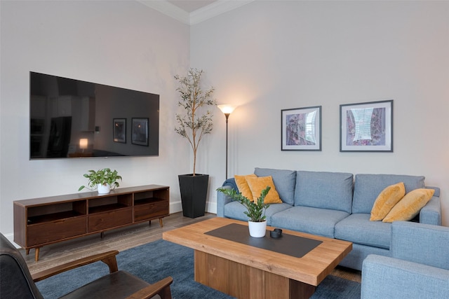 living room featuring baseboards, ornamental molding, and wood finished floors
