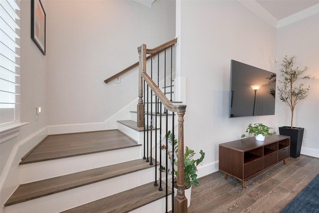 stairs with crown molding, baseboards, and wood finished floors