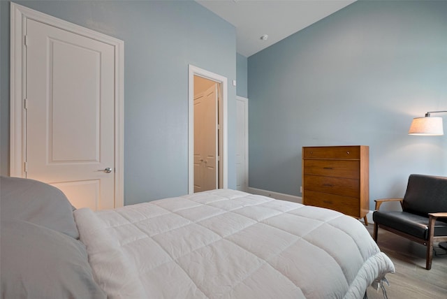 bedroom with baseboards and vaulted ceiling