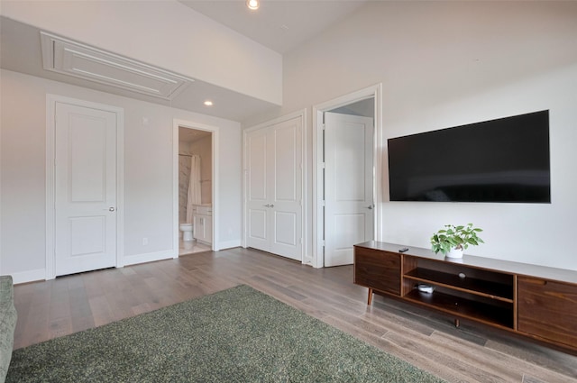 bedroom with ensuite bathroom, attic access, wood finished floors, and recessed lighting