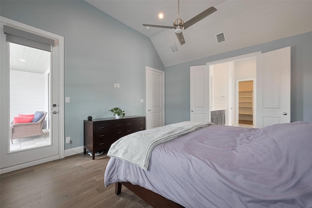 bedroom with visible vents, wood finished floors, lofted ceiling, and ensuite bath