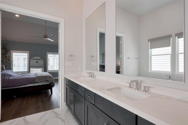 bathroom featuring a sink, marble finish floor, double vanity, and connected bathroom