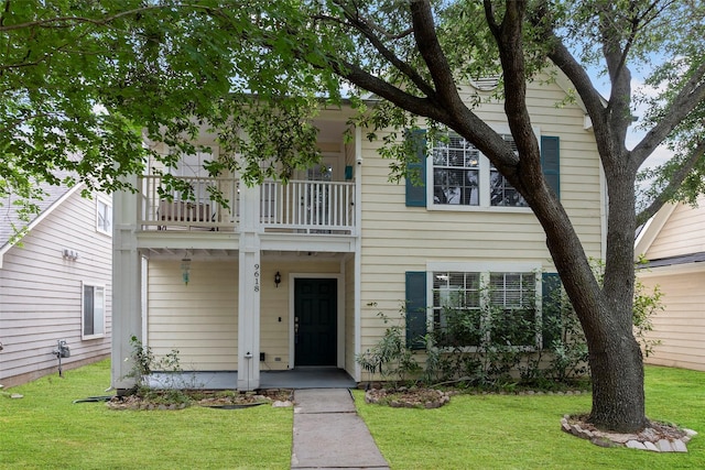 view of front of property with a porch, a front lawn, and a balcony