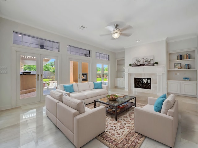 living area featuring ceiling fan, built in features, french doors, a high end fireplace, and visible vents